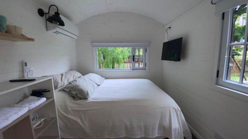 une petite chambre avec un lit et une fenêtre dans l'établissement Las Cabañas de City Bell - El Sauce, à City Bell