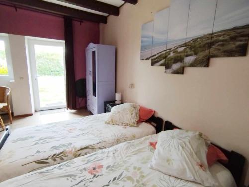 1 dormitorio con 2 camas y un cuadro en la pared en Gîte des Fours, en Agonges