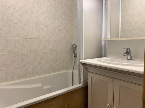 a white bathroom with a sink and a bath tub at Résidence Courmayeur - 2 Pièces pour 6 Personnes 874 in Les Menuires