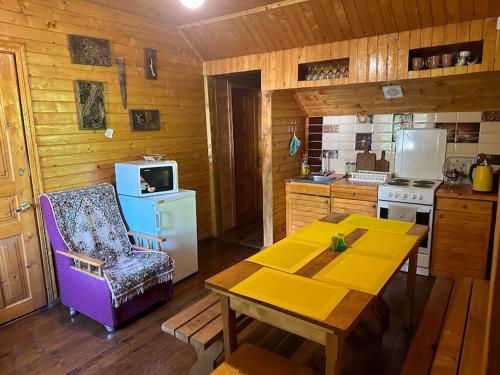 eine Küche mit einem Tisch, einem Stuhl und einem Herd in der Unterkunft Садиба над потічком in Oriv