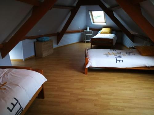 - une chambre mansardée avec 2 lits et une fenêtre dans l'établissement maison les vieilles cours, à Blosville
