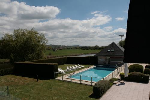 a swimming pool in a yard next to a house at Kyriad Deauville - St Arnoult in Deauville
