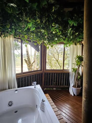 a bath tub in a room with windows at Eden Hotel in El Peñol