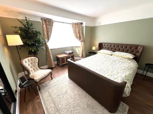 ein Schlafzimmer mit einem Bett, einem Stuhl und einem Fenster in der Unterkunft Spacious 3 bed APT sleeps 5 near Bournemouth Beach in Bournemouth