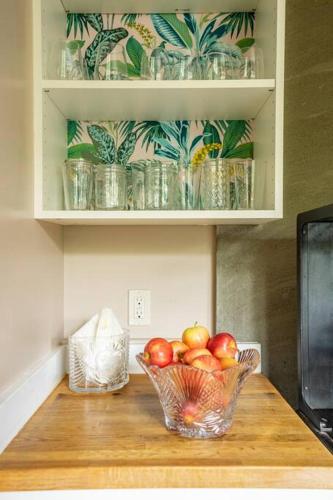 a bowl of fruit on a wooden table with a bowl of apples at Charming Room in Historic BnB with Parking - Rm 5 in Seattle