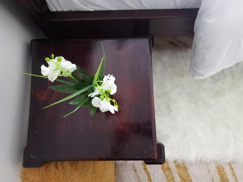 a wooden table with white flowers on top of a bed at Kai Suite Kitale in Kitale