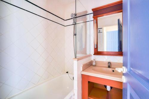 une salle de bain avec un lavabo, une baignoire et un miroir dans l'établissement Résidence Lacanau Les Pins - maeva Home - Appartement 2 pièces 4 personnes - Sélection MAE-5031, à Lacanau