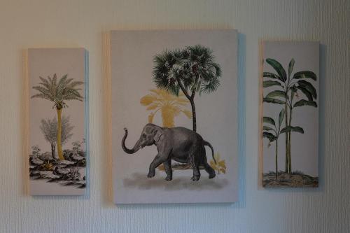 a painting of an elephant on a wall with palm trees at The Eden Apartment, Edinburgh City Center in Edinburgh