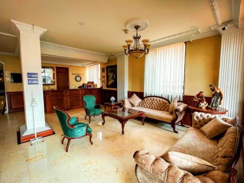 a large living room with couches and chairs at Hotel Castilla Real in Pereira