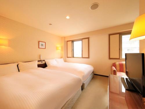 Centurion Hotel Hamamatsu في هاماماتسو: غرفة فندقية بسريرين وتلفزيون