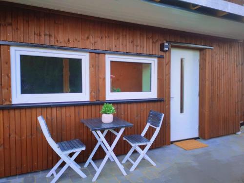 eine Terrasse mit 2 Stühlen, einem Tisch und 2 Fenstern in der Unterkunft Mossemarka Guesthouse in Moss