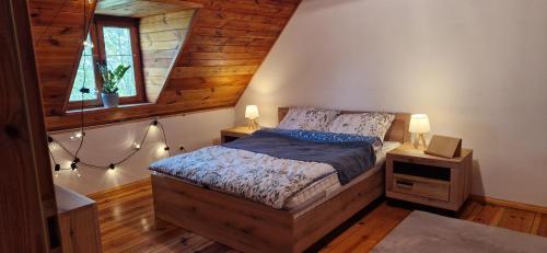 sypialnia z łóżkiem i 2 lampkami na stołach w obiekcie Dworek Wołyński - Winnica Zegartowice 