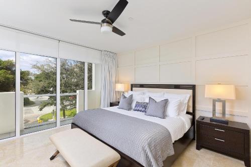 um quarto com uma cama e uma grande janela em Hemingway Poolside em Deerfield Beach