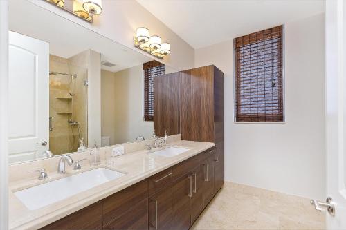 uma casa de banho com 2 lavatórios e um espelho grande em Hemingway Poolside em Deerfield Beach
