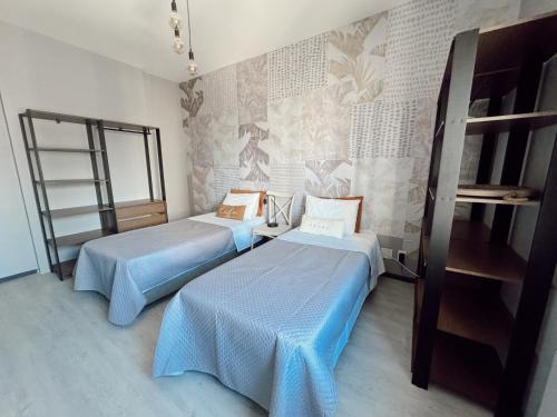 2 Betten in einem Zimmer mit einer Wand in der Unterkunft Flat Luxury Chelsea frente ao Dona Lindu in Recife