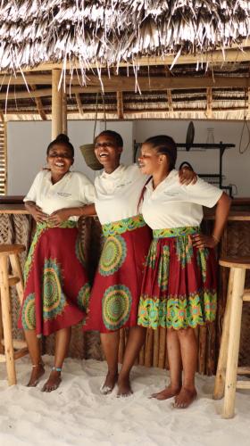a group of three people standing on the beach at Mlango Paje Villa Boutique in Paje