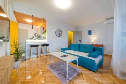 a living room with a blue couch and a table at Apartman Nika in Pirot