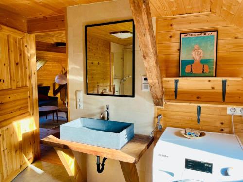 uma casa de banho com um lavatório e um espelho em Penthouse im Bauernhaus em Laas