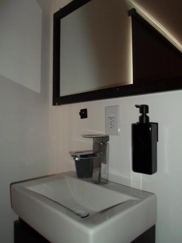 lavabo blanco en el baño con espejo en Hotel María Bonita, en Tlaxcala de Xicohténcatl