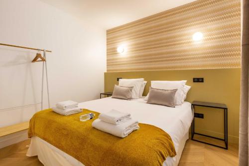 ein Schlafzimmer mit einem großen weißen Bett mit Handtüchern darauf in der Unterkunft Chic Apartment in the Prestigious Saint Honoré in Paris