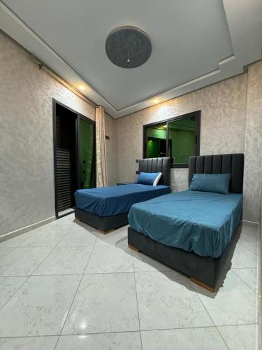 2 Betten in einem Zimmer mit 2 Fenstern in der Unterkunft Magnifique appartement in Derroua
