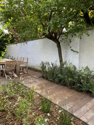 a patio with two chairs and a table and a tree at Luxury Apartment with Cosy Garden! in Ghent