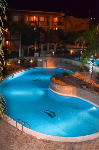 a large blue swimming pool at night at Hotel Colonial Hermosillo in Hermosillo