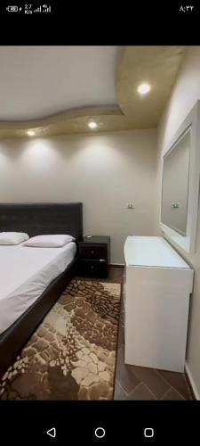 een kleine slaapkamer met een bed en een televisie bij Dokki in Caïro