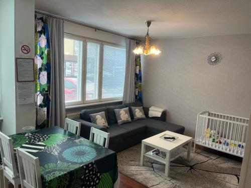 una pequeña sala de estar con sofá y cuna en Siisti ja kodikas asunnon keskustassa+free parking, en Kuopio
