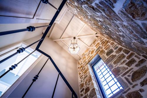 a room with a stone wall and a chandelier at RODON Luxury Villas in Skopelos Town
