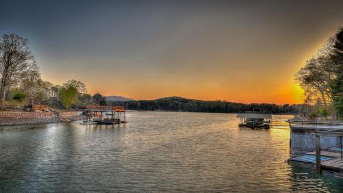 two boats are docked on a river at sunset at Lake Cove Oasis in Morganton