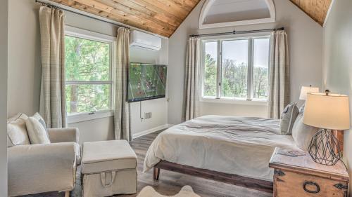 a bedroom with a bed and a chair and windows at Lake Cove Oasis in Morganton