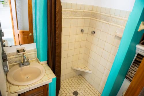 a small bathroom with a sink and a shower at Sayulita Central Hotel in Sayulita
