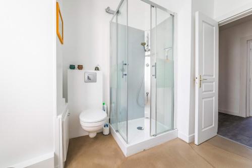 a bathroom with a toilet and a glass shower at La Villa Lumière - 3 chambres in Tulle