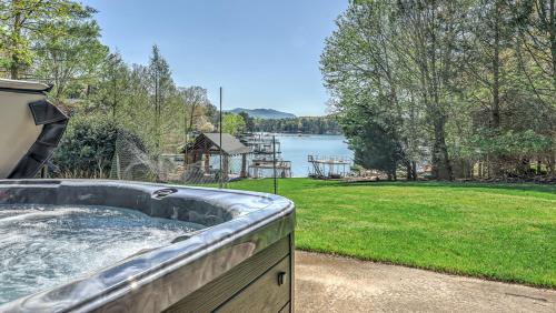 a hot tub in a backyard with a view of a lake at Lake Cove Oasis in Morganton