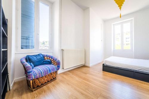 a bedroom with a bed and a chair at La Villa Lumière - 3 chambres in Tulle