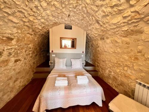 a bedroom with two beds in a stone wall at Appartement Typique in Provencal village Menerbes in Ménerbes