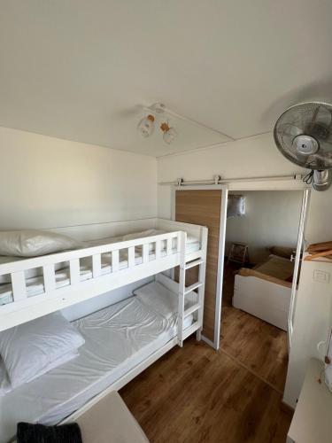 - une chambre avec 2 lits superposés et un ventilateur dans l'établissement Studio face à l'étang pour 5 Voyageurs Port-Leucate, à Leucate