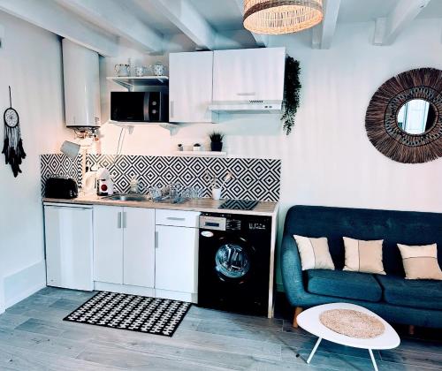 une cuisine avec un canapé bleu et un lave-vaisselle dans l'établissement Serenity - Garden Calm & Air Conditioning Downtown, à Saint-Laurent-du-Var
