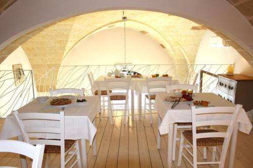 ein Esszimmer mit weißen Tischen und weißen Stühlen in der Unterkunft Palazzo Aurora in Alezio