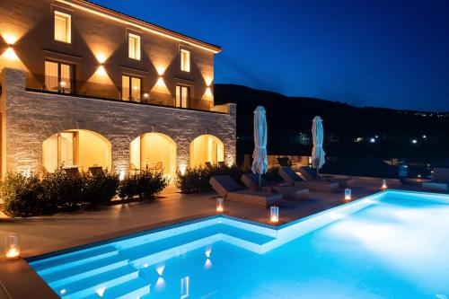 a villa with a swimming pool at night at Reveli Suites in Katelios