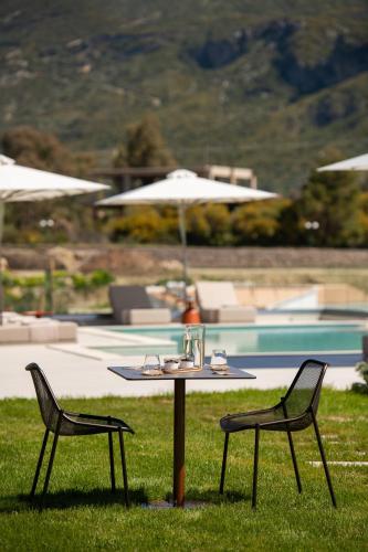 a table and two chairs sitting next to a pool at Reveli Suites in Katelios