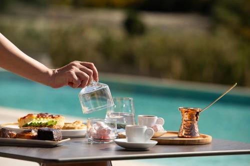 a person is serving food on a table at Reveli Suites in Katelios
