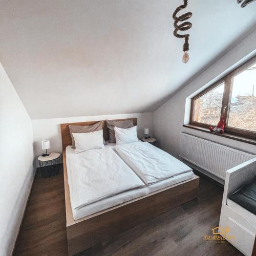 a bedroom with a large bed and a window at Ďumbierky Chata 6ka in Mýto pod Ďumbierom