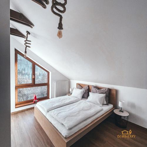 a bedroom with a bed and a window at Ďumbierky Chata 6ka in Mýto pod Ďumbierom