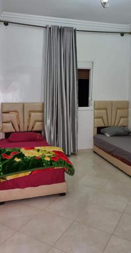 een slaapkamer met 2 bedden en een raam bij تجزئة القلم حي أطلس بني ملال 