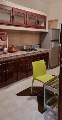 una cocina con una silla verde y una barra en تجزئة القلم حي أطلس بني ملال, 