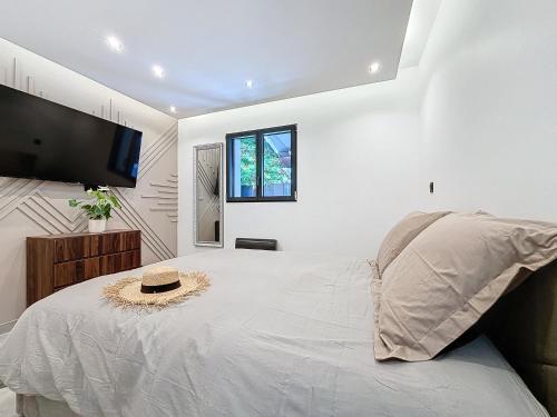 - une chambre dotée d'un grand lit avec un chapeau dans l'établissement La Suite EDEN - Maison de ville Luxe - 4pers - Jacuzzi - 10min Cannes, au Cannet