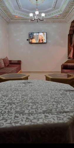 a living room with a couch and a tv on the wall at تجزئة القلم حي أطلس بني ملال in Mrhila