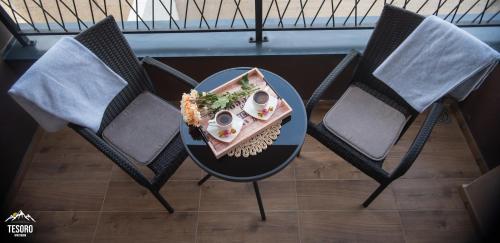 a table and chairs with a plate of food on it at Tesoro apartmani Spa&Wellness in Zlatibor